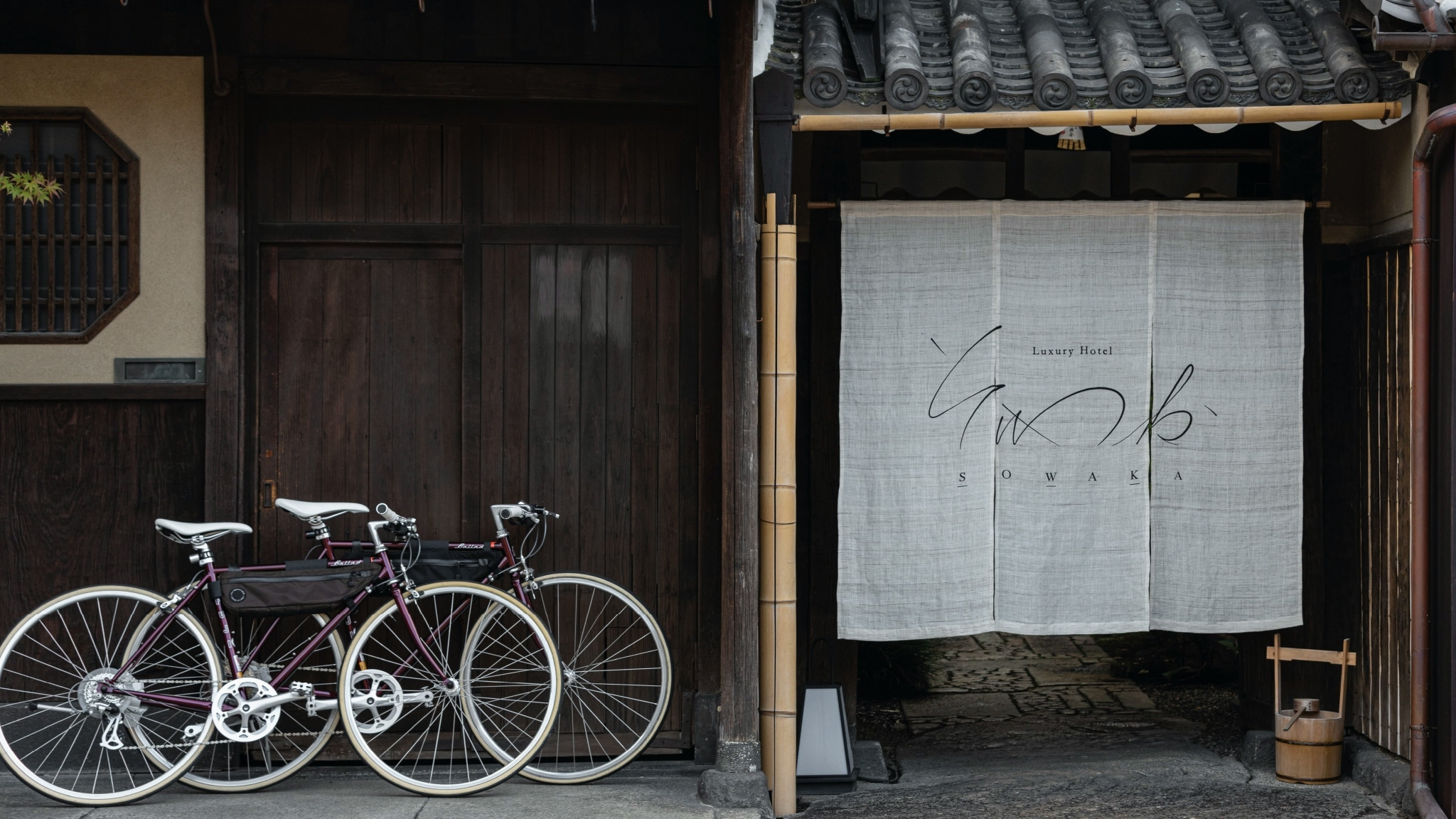 Entrance of SOWAKA, with the noren (curtain) and two bicycles outside.