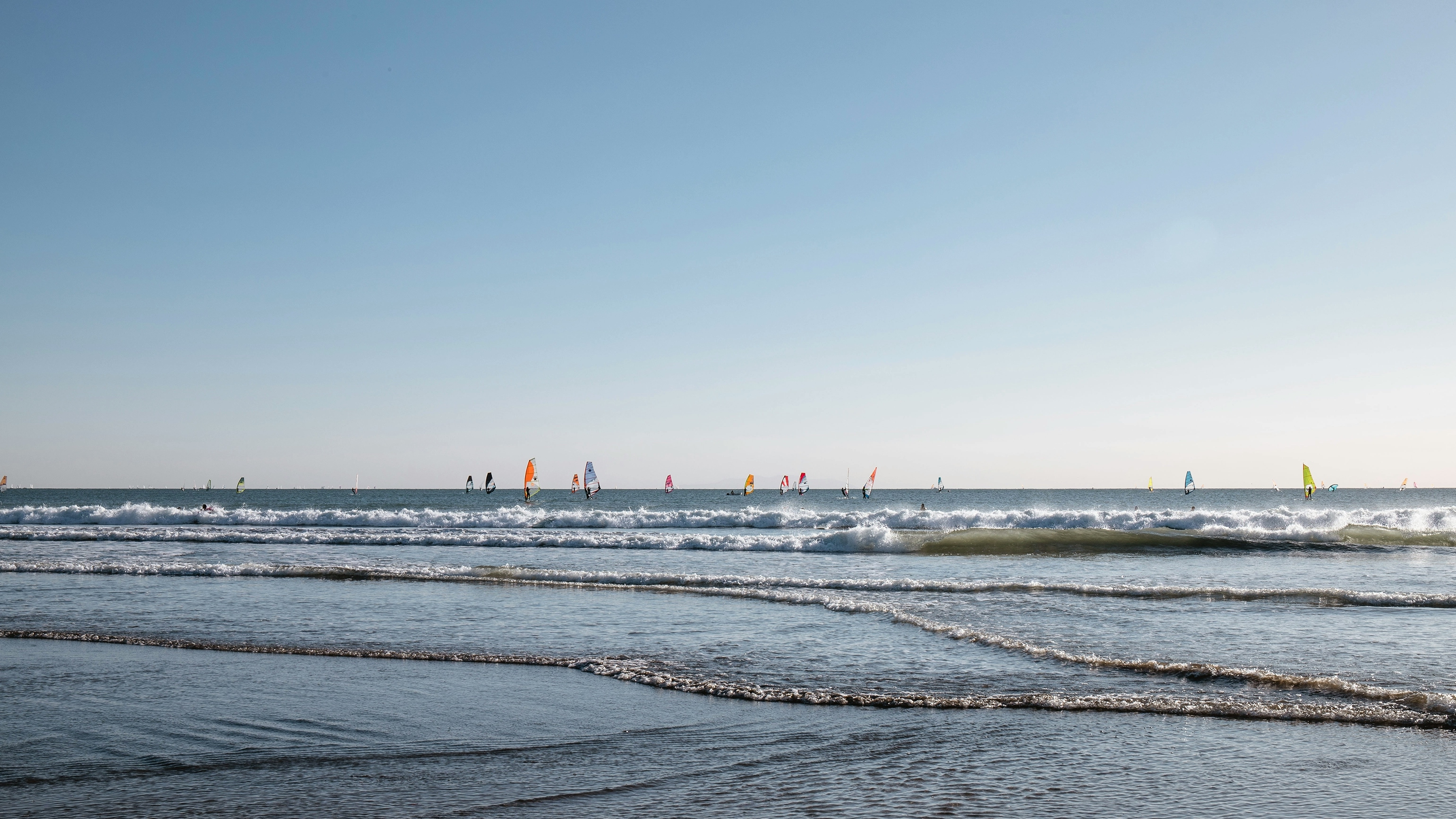 A colourful array of windsurf sails dot the horizon of Yuigahama Beach.