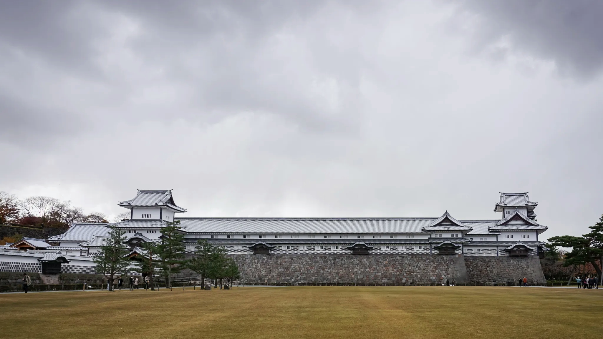 Kanazawa Castle stands against a backdrop of a cloud-laden sky