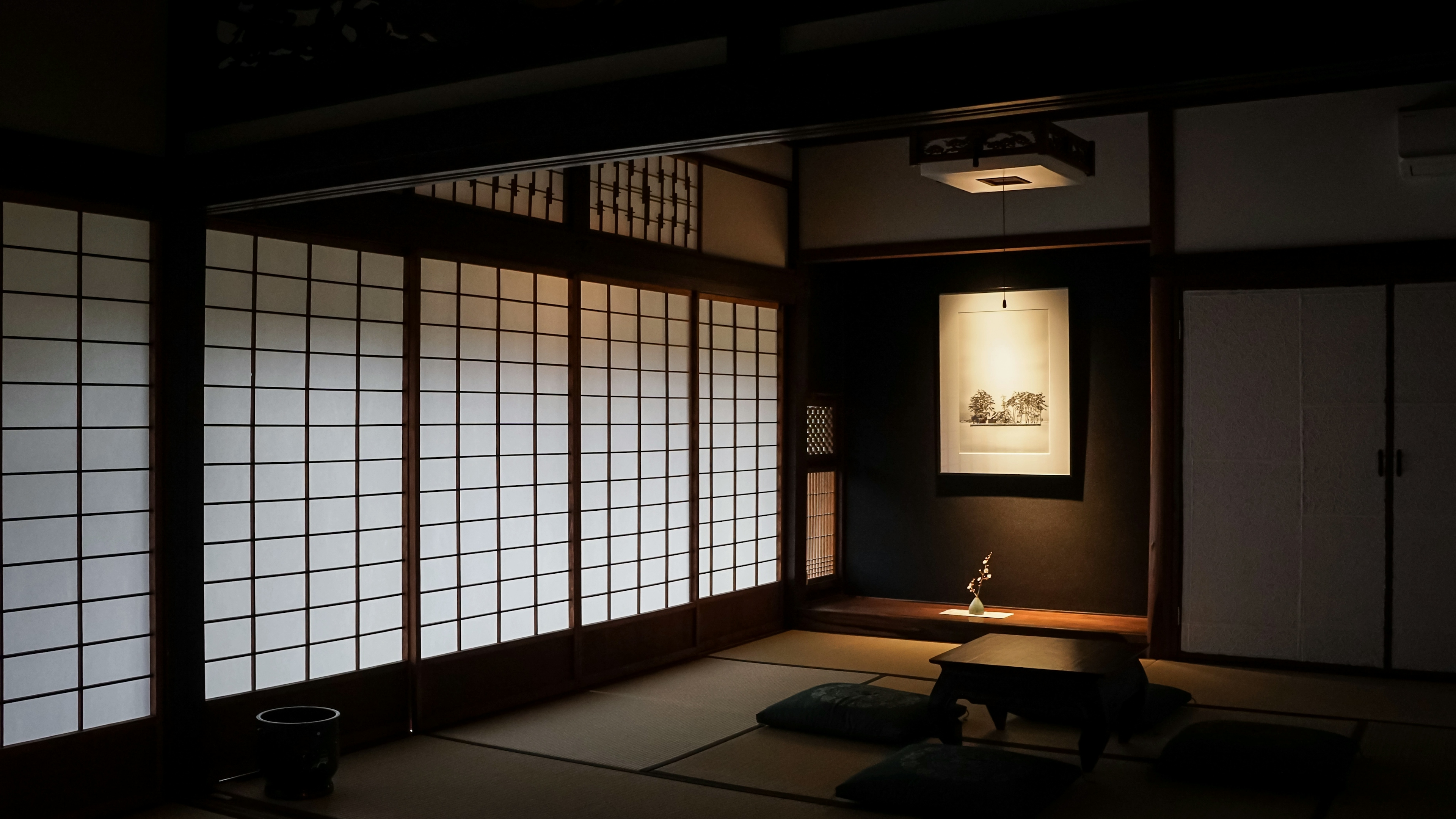 Main room with tatami mats, fusama (sliding screens) and decorative print.